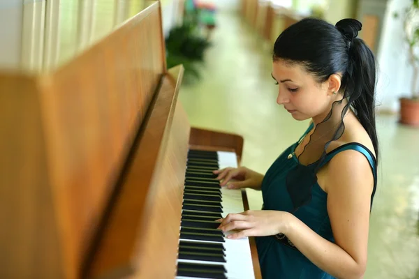 Beautiful young attractive woman in cocktail dress and piano — Stock Photo, Image