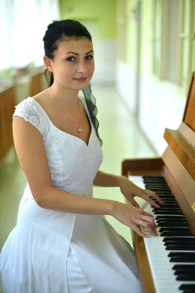 Gyönyörű fiatal vonzó nő, koktél ruha és zongora — Stock Fotó