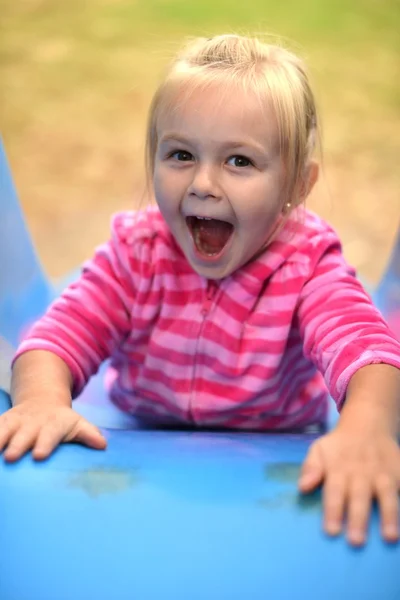 Attractive little girl on outdoor playground equipment — Stock Photo, Image