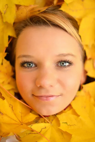 Junge Frau mit Herbstblättern — Stockfoto