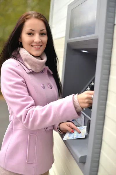 Frau hebt am Geldautomaten Geld von Kreditkarte ab. — Stockfoto