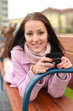 güzel genç kadın ile şehir içinde hareket eden hücre telefon. portre, boşaltmak.