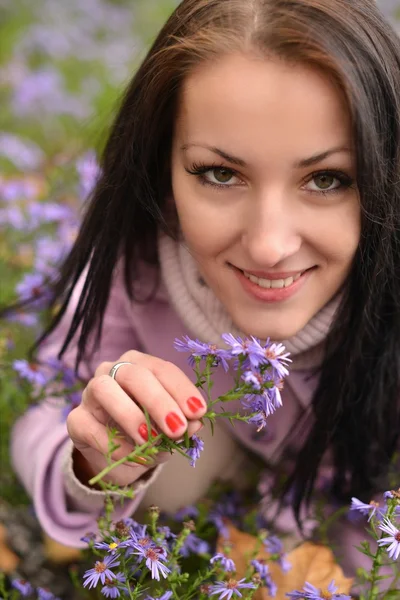 Χαριτωμένο νεαρή γυναίκα με λουλούδια — Φωτογραφία Αρχείου