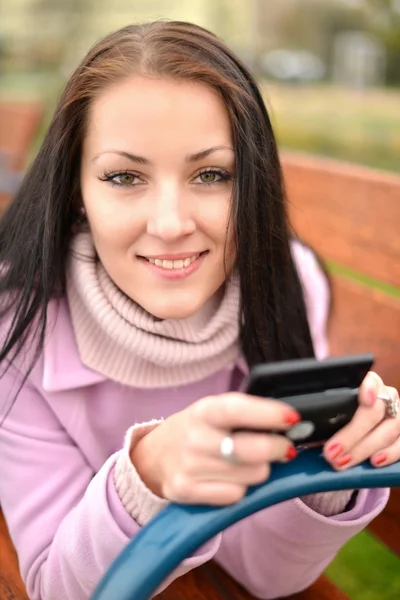 Hermosa mujer joven con teléfono celular en la ciudad. Primer plano, copyspace . —  Fotos de Stock