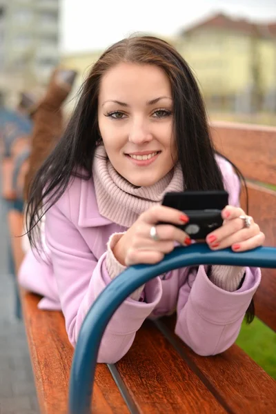 Beautiful young woman with mobile cell phone in city. Closeup, copyspace. — Stock Photo, Image