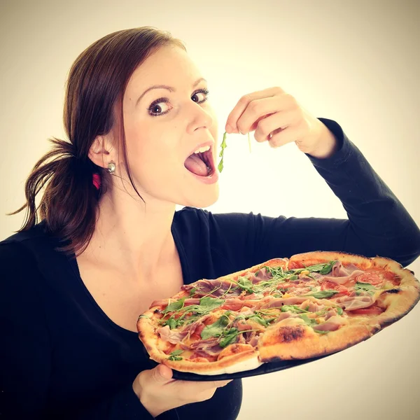 Portret van een jonge vrouw een pizza eten op een witte achtergrond — Stockfoto