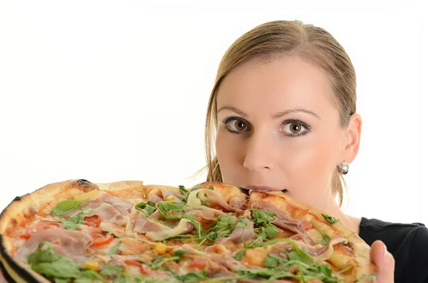 Retrato de una joven comiendo una pizza sobre un fondo blanco — Foto de Stock