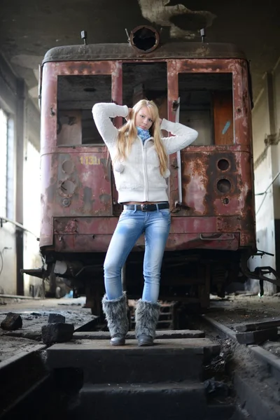 Ung kvinna som står nära ett tåg — Stockfoto