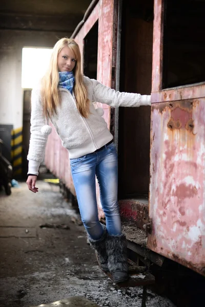 Giovane donna in piedi vicino a un treno — Foto Stock