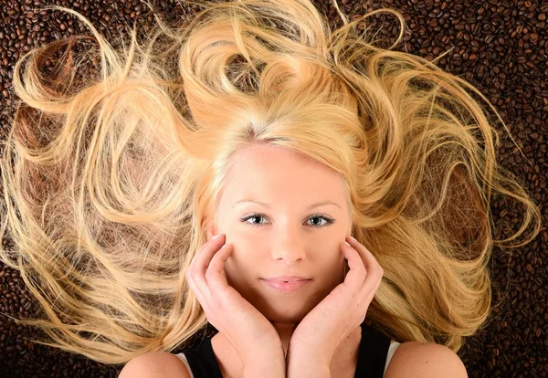 Portrait of a girl's face drowned in coffee beans — Stock Photo, Image