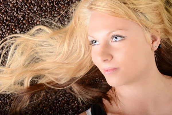 Portrait of a girl's face drowned in coffee beans — Stock Photo, Image