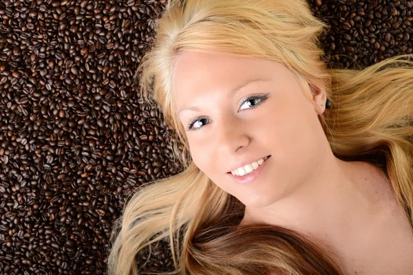 Retrato do rosto de uma menina afogada em grãos de café — Fotografia de Stock