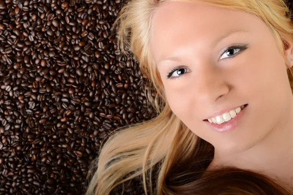 Retrato do rosto de uma menina afogada em grãos de café — Fotografia de Stock