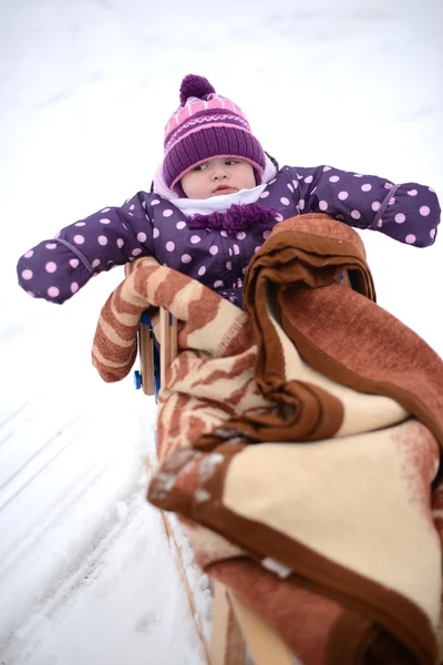 Das Kind reitet im Winter die Hügel hinunter — Stockfoto