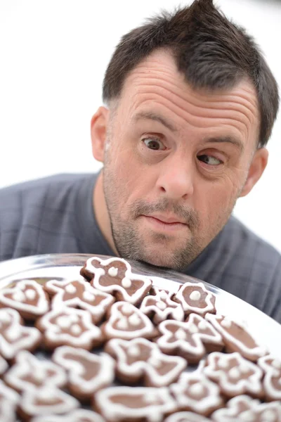 Christmas man with Down syndrome holding gingerbread — Stock Photo, Image