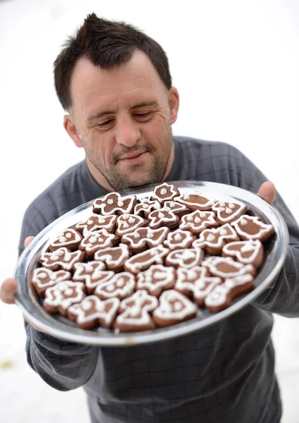 Christmas man with Down syndrome holding gingerbread — Stock Photo, Image