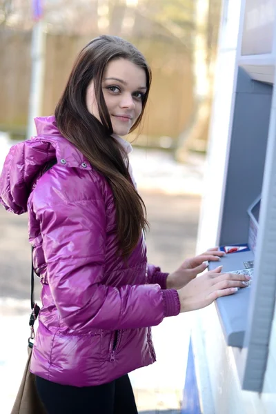 Žena vybírá peníze z kreditní karty v bankomatu. — Stock fotografie