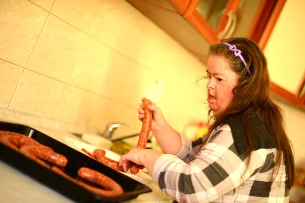 Aantrekkelijke down syndroom vrouw aanspanning in de keuken — Stockfoto