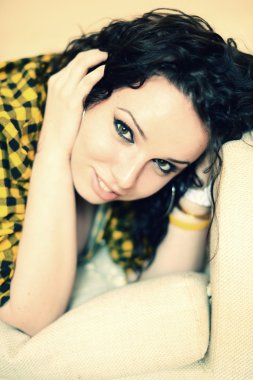 Kanepede televizyon izleyen mutlu genç bir kadın.