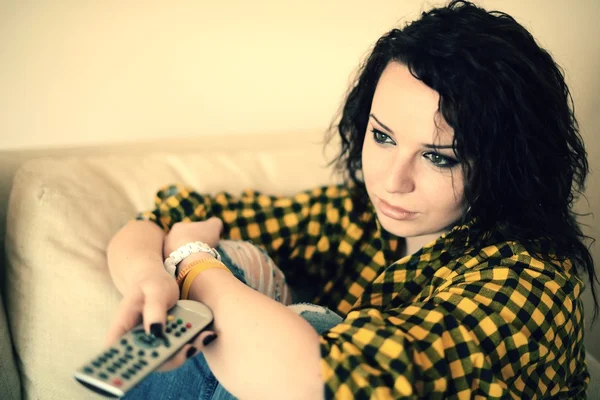 Feliz joven mujer viendo la televisión en el sofá — Foto de Stock