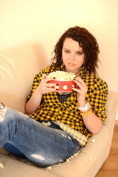 Feliz joven mujer viendo la televisión en el sofá — Foto de Stock