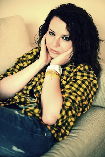 Happy young woman watching tv on sofa — Stock Photo, Image