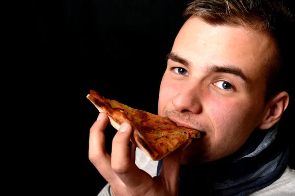 Mladý muž, jíst pizzu — Stock fotografie