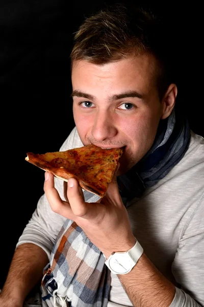 Ung man äta pizza — Stockfoto