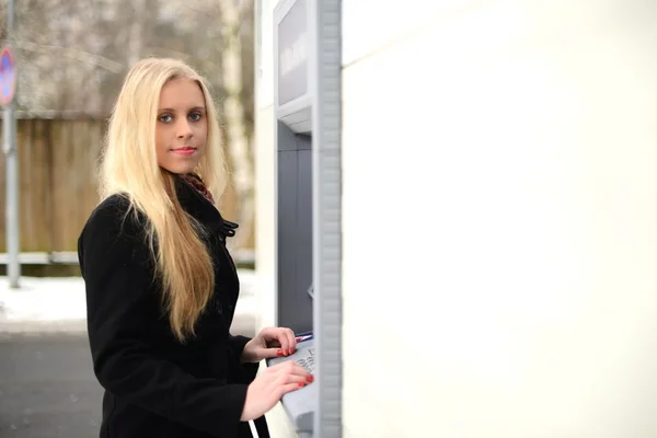 Na skałachdziewczyna zwraca się pieniądze w gotówce atm — Zdjęcie stockowe