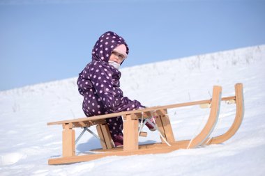 küçük kız kızak kış aylarında kar üzerinde rulo.