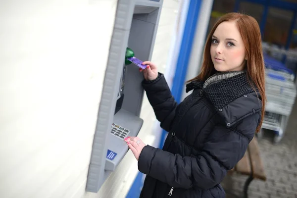 Frau hebt am Geldautomaten Geld von Kreditkarte ab — Stockfoto