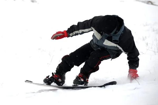 Giovane uomo che cerca di cavalcare snowboard — Foto Stock