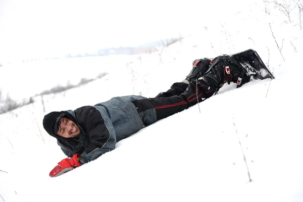 Joven tratando de montar snowboard —  Fotos de Stock