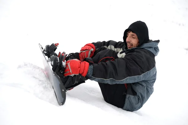 Jovem tentando andar de snowboard — Fotografia de Stock