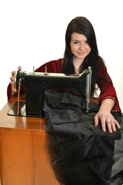 Mujer joven caucásica usando una máquina de coser . — Foto de Stock