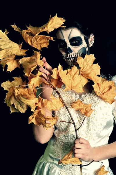 Fille avec peinture mort masque crâne avec des feuilles — Photo