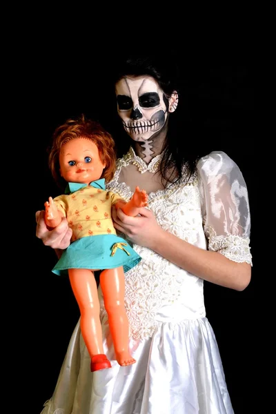 Girl with painting dead mask skull with doll — Stock Photo, Image