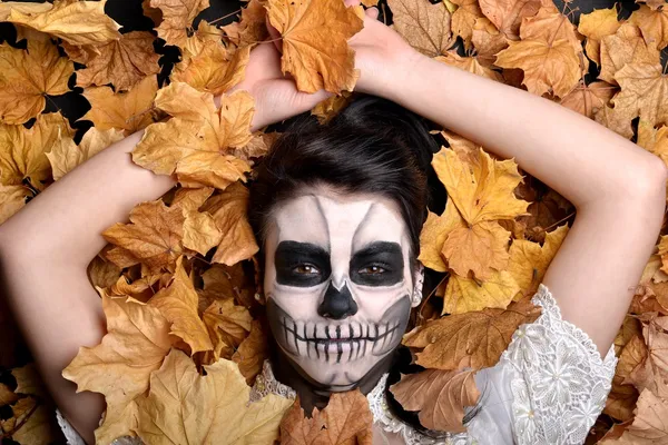 Meisje met schilderij dode masker schedel met bladeren — Stockfoto