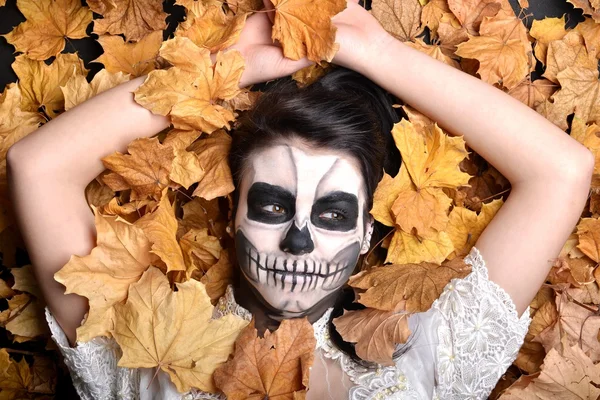 Fille avec peinture mort masque crâne avec des feuilles — Photo