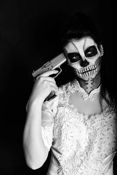 Flicka med målning död mask skalle med pistol — Stockfoto
