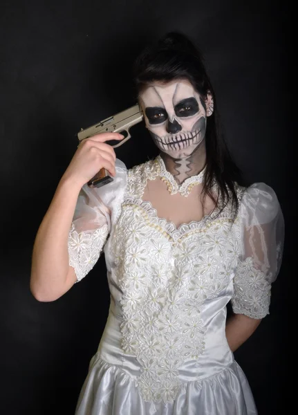 Girl with painting dead mask skull with gun — Stock Photo, Image