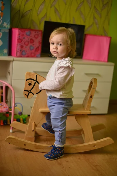 Little girl rides a toy rocking — Stock Photo, Image