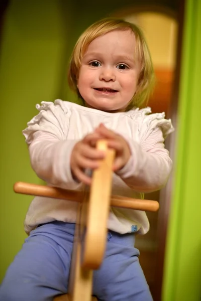 Little girl rides a toy rocking — Stock Photo, Image