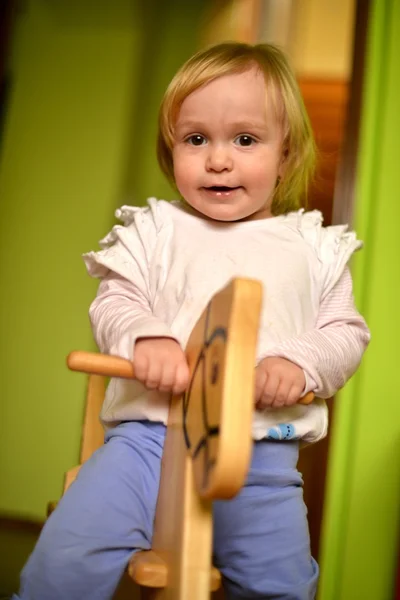 Bambina cavalca un giocattolo dondolo — Foto Stock