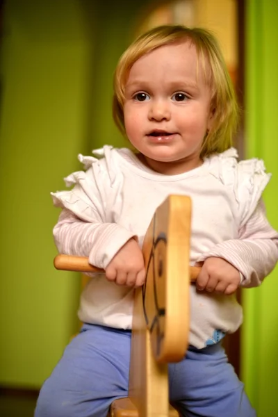 Menina monta um brinquedo balançando — Fotografia de Stock