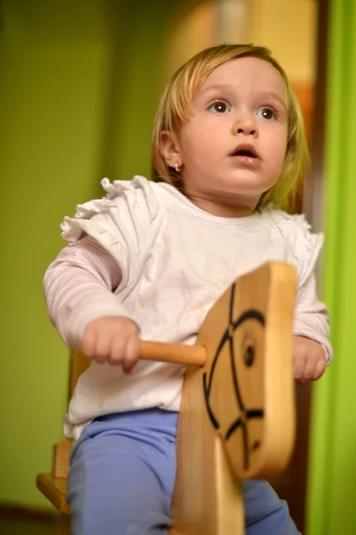 Bambina cavalca un giocattolo dondolo — Foto Stock