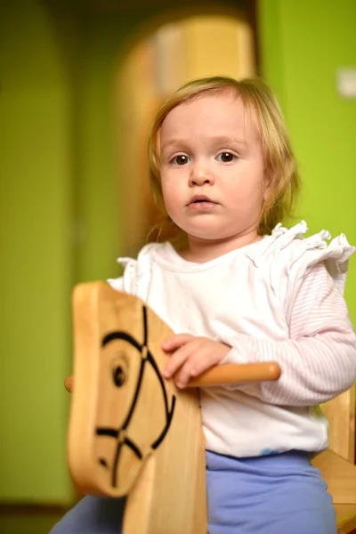 Kleines Mädchen reitet ein Spielzeug schaukelnd — Stockfoto