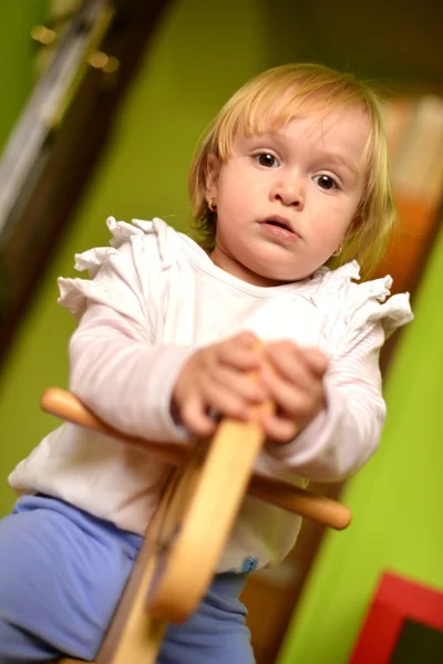 Bambina cavalca un giocattolo dondolo — Foto Stock