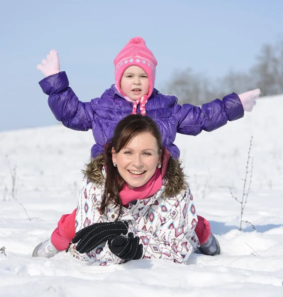 Mother sits on sled in park with child at winter — Stock Photo, Image
