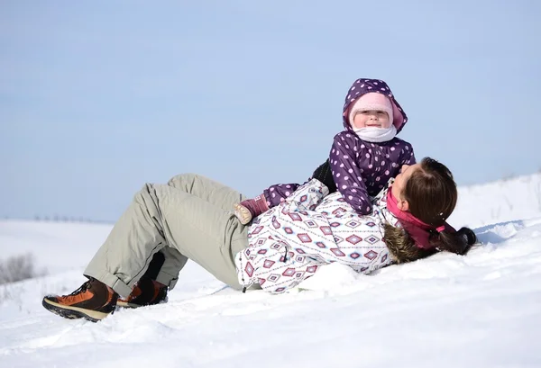 Moeder zit op slee in park met kind op winter — Stockfoto